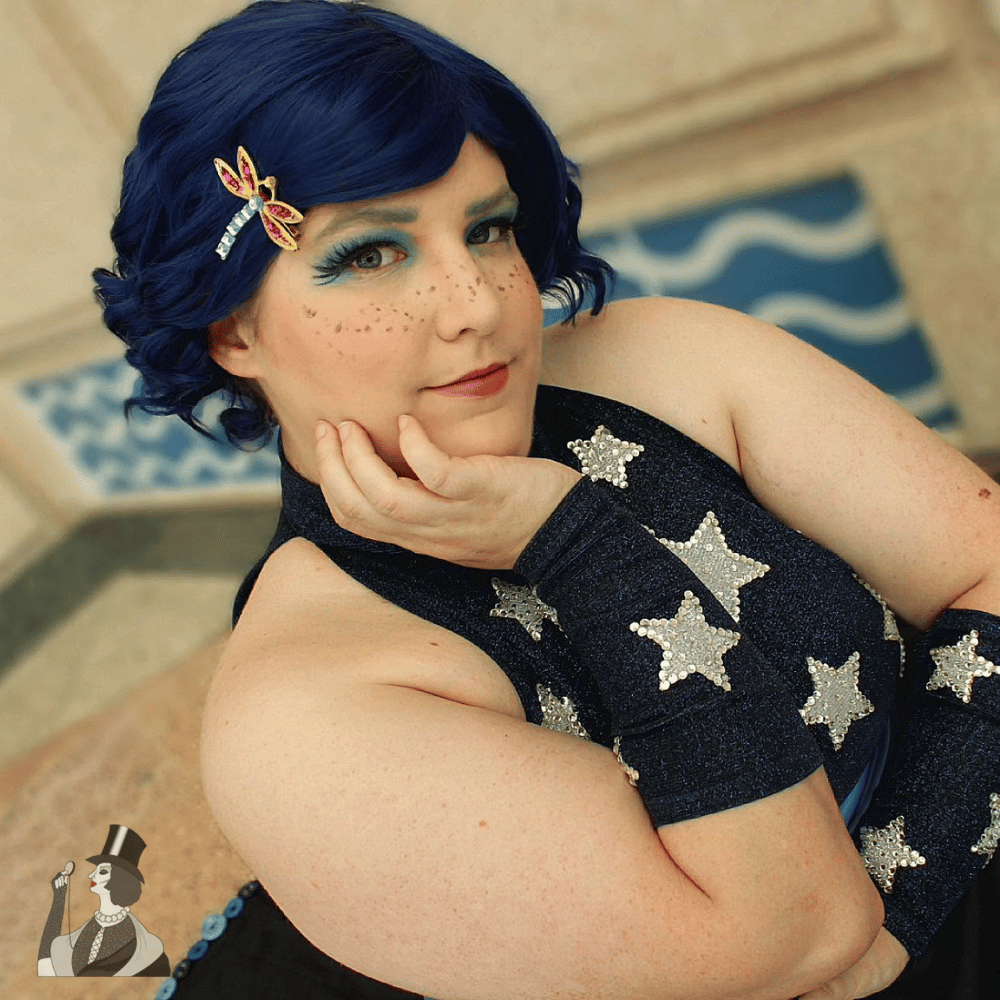 Emma in cosplay, blue halter top with silver stars, and a blue wig
