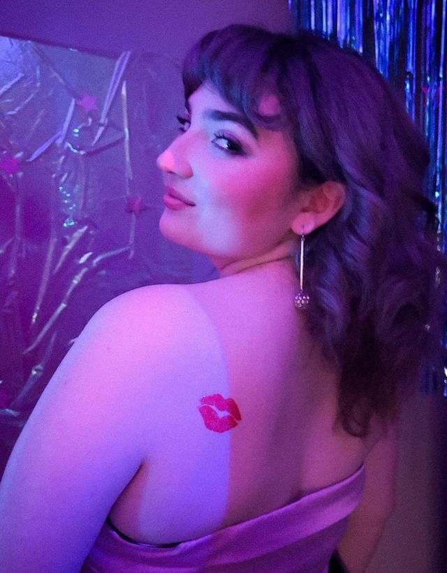 smirking girl looking over her shoulder with lipstick kiss mark
